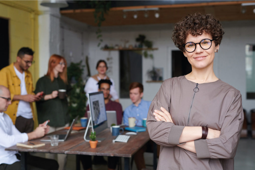 photo of woman in office space with team in the background